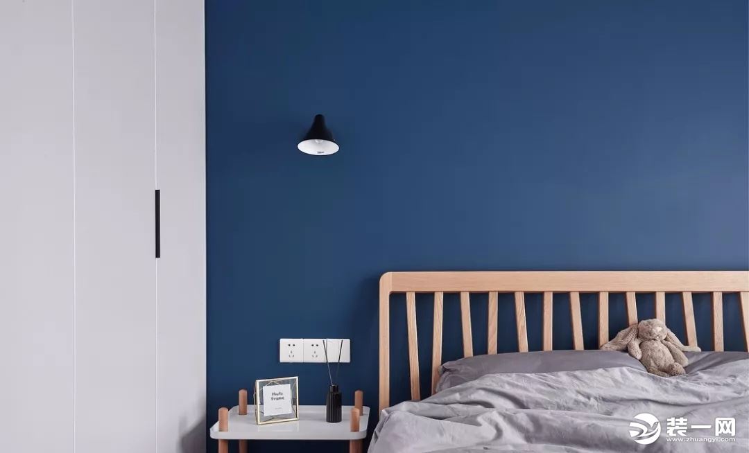 主卧非常大胆的选择了深蓝色墙面,搭配原木大床,灰色床品,营造安静